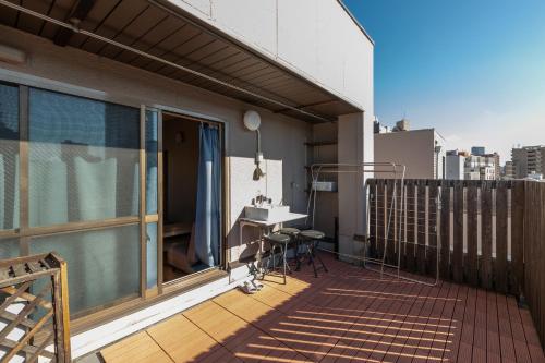 a balcony with a desk on a building at Guesthouse YOURS in Osaka
