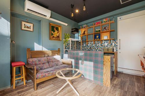 a living room with a couch and a table at Guesthouse YOURS in Osaka
