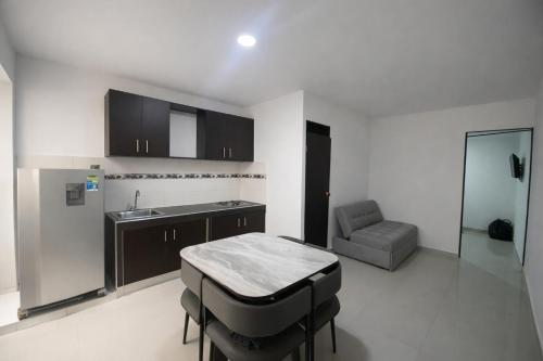 a kitchen with a table and a sink and a couch at Inmosolaris in Cali