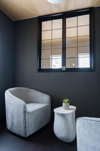 a living room with a chair and a table at The Crane Sanctuary Kamifurano in Kami-furano