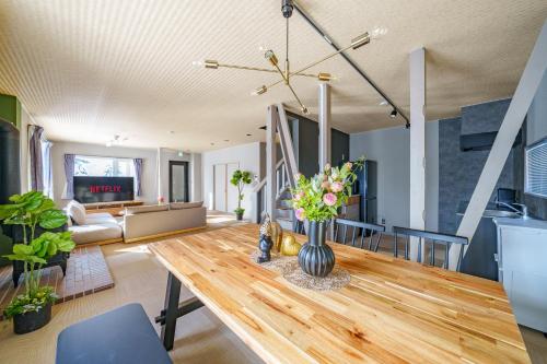a living room with a table with flowers on it at The Crane Sanctuary Kamifurano in Kami-furano