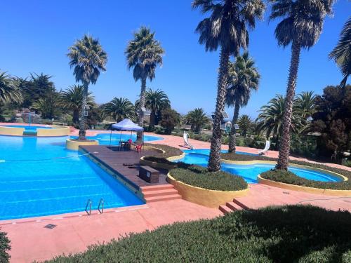 una piscina con palme in un resort di Ilimay a Las Cruces