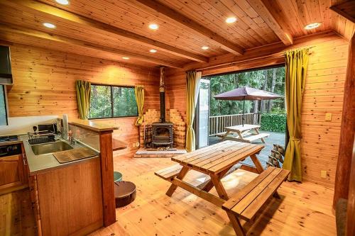 a kitchen with a wooden cabin with a table and a stove at るり渓森の宿 灯 akari in Nantan city