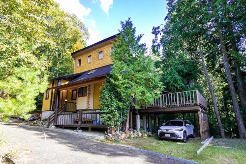 a house with a car parked in front of it at るり渓森の宿 灯 akari in Nantan city
