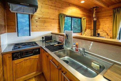 a kitchen with a sink and a stove at るり渓森の宿 灯 akari in Nantan city