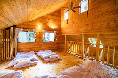 a bedroom with two beds in a wooden cabin at るり渓森の宿 灯 akari in Nantan city