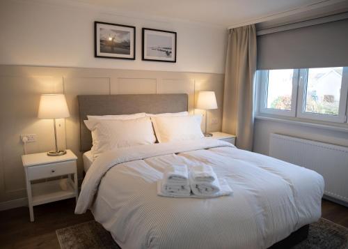 a bedroom with a white bed with two towels on it at Justina's House in East Kilbride