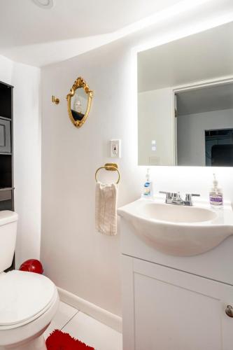 a white bathroom with a sink and a mirror at Updated Apt with Private Entry and FREE Parking in Washington, D.C.