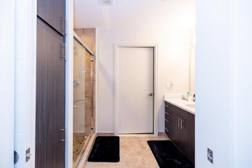 a bathroom with a shower and a white door at Penthouse Retreat with Rooftop Pool Explore Silver Spring & Washington DC in Silver Spring