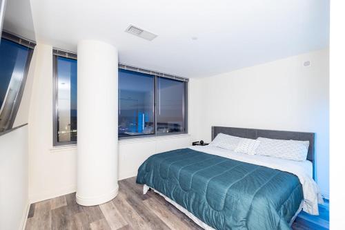 a white bedroom with a bed and windows at Penthouse Retreat with Rooftop Pool Explore Silver Spring & Washington DC in Silver Spring