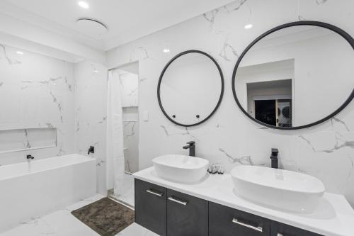 a white bathroom with two sinks and a mirror at Forest view guesthouse in Runcorn