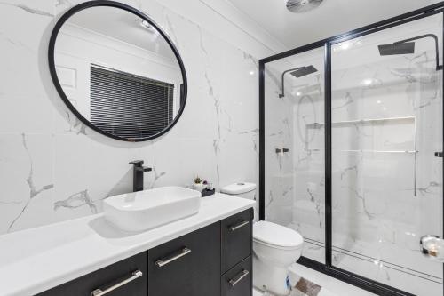 a white bathroom with a sink and a mirror at Forest view guesthouse in Runcorn