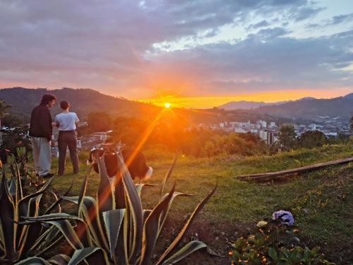 two people standing on a hill looking at the sunset at Buriti EcoH RNT56521, via Termales Santa Rosa de Cabal in Santa Rosa de Cabal