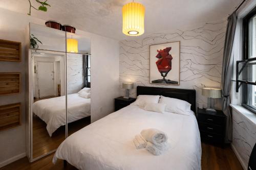 a bedroom with two beds and a mirror at Next to Manhattan 2 Bedrooms Apartment - Subway 20 steps, Manhattan 1 Stop in Roosevelt Island