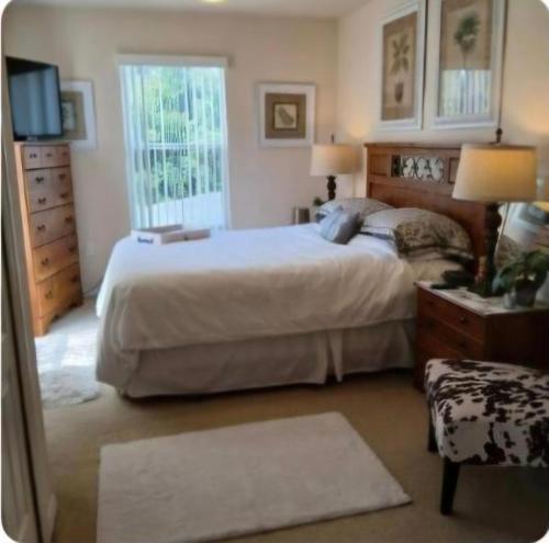 a bedroom with a large bed and a window at NO DAY OF BOOKING 24 HOURS NOTICE One private Master Efficency Suite Room with Bathroom for one person or couple with a pool breakfast included message here or email Floridastylz74 g mail com in Davenport