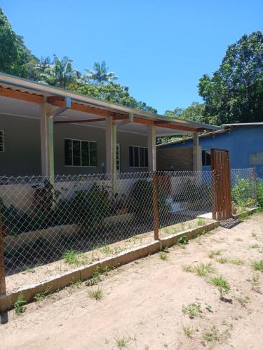 a house with a fence in front of it at Kitnet na mata atlantica in Ubatuba