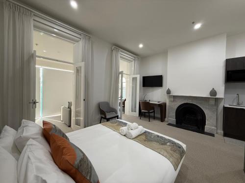a bedroom with a large bed and a fireplace at Sixty Two On Grey Serviced Apartments in Melbourne