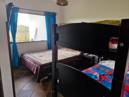 a bedroom with two bunk beds and a window at Villa Alejandra in Quebrada Vieja