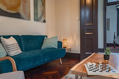 a living room with a green couch and chessboard on a table at Vista Verde Retreat in Bretanha