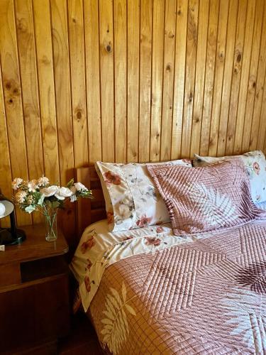 ein Schlafzimmer mit einem Bett und einer Holzwand in der Unterkunft Cabañas Anny 1 in Linares