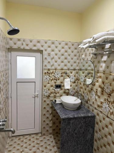a bathroom with a sink and a door in it at Hotel Diamond Crest, Patna in Patna