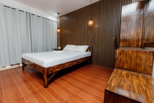 a bedroom with a bed and a wooden wall at Villa Gertrudes Beach Resort in Surigao
