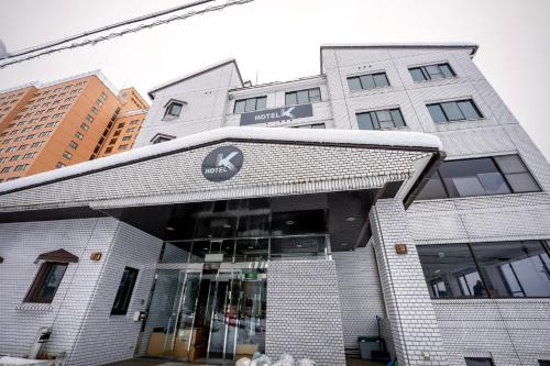 a building with a sign on the front of it at Hotel K Yuzawa 越後湯澤溫泉旅館 in Yuzawa