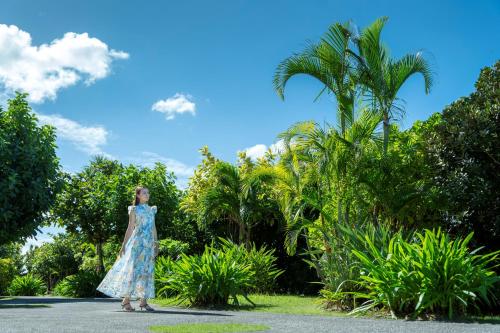 a woman in a dress standing in front of trees at Southern Beach Hotel & Resort Okinawa in Itoman