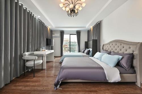 a bedroom with a bed and a chair and a chandelier at M Home Riverside in Ho Chi Minh City