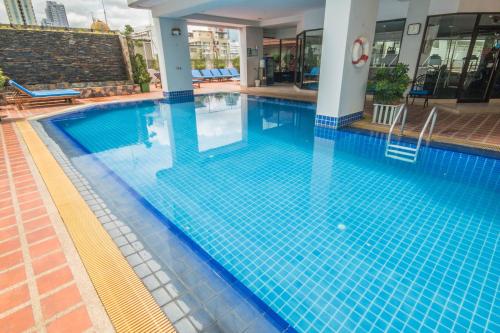 a swimming pool with blue tiles in a building at Tai Pan Hotel in Bangkok