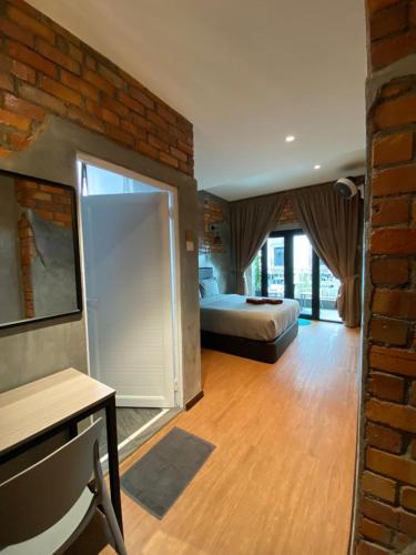 a bedroom with a bed and a brick wall at Bricks Guesthouse in Tanah Rata