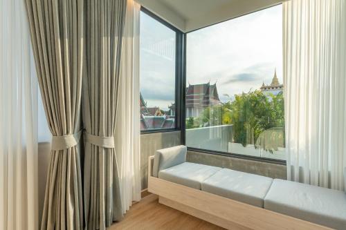 a living room with a large window with a couch at The Chedee Krungthep in Bangkok