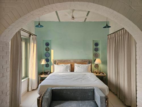 a bedroom with a large bed with an archway at Kadamb Bagh-A Luxury Nature Resort Sariska in Rāmsinghpura