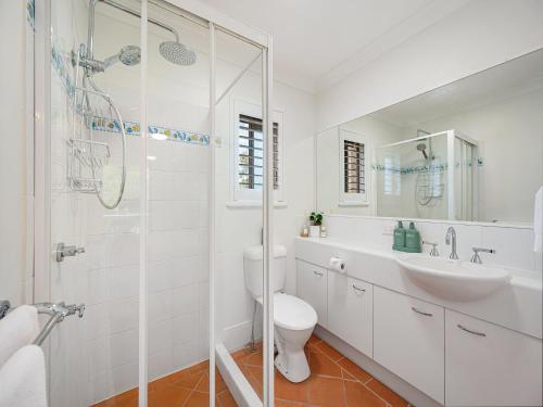 a white bathroom with a sink and a shower at Seabreeze unit 5, Kings Beach in Caloundra