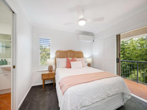 a white bedroom with a bed and a window at Seabreeze unit 5, Kings Beach in Caloundra