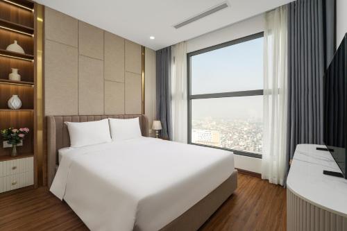 a bedroom with a large white bed and a large window at Aravelle Suites managed by 22Land in Hanoi