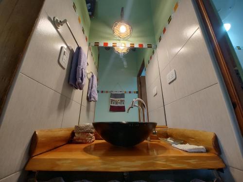 a bathroom with a bowl sink on a wooden counter at Cabañas Mónika IV Sur in Huerta Grande