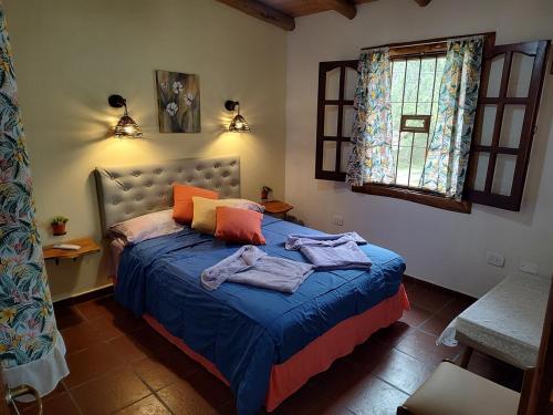 a bedroom with a bed with towels on it at Cabañas Mónika IV Sur in Huerta Grande