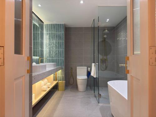 a bathroom with a tub and a toilet and a sink at Crystal Crown Hotel Kuala Lumpur in Kuala Lumpur