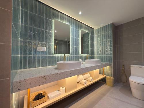 a bathroom with two sinks and a toilet and a mirror at Crystal Crown Hotel Kuala Lumpur in Kuala Lumpur