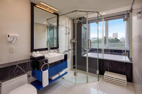 a bathroom with a shower and a sink and a tub at Minerva Church Hotel in Hanoi