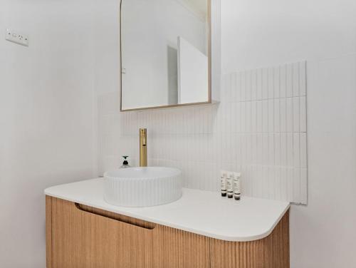 a bathroom with a white sink and a mirror at Sea Side Glide at Maloneys Hide in Maloney's Beach