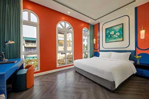 a bedroom with orange walls and a bed and windows at Minerva Church Hotel in Hanoi