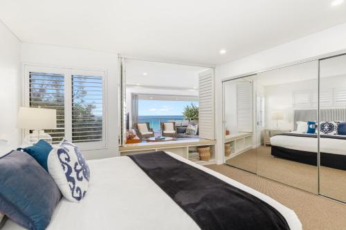 a bedroom with a bed and a view of the ocean at Waves #9 by Discover Stradbroke in Point Lookout