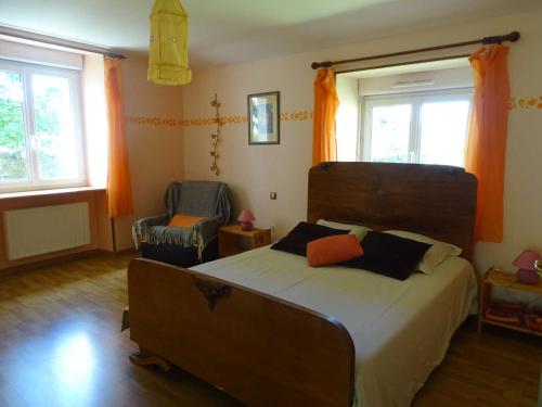 a bedroom with a large bed and two chairs at L'étable aux deux noix in Arc-en-Barrois