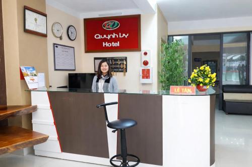 a woman sitting at a counter in a waiting room at Quỳnh Vy Hotel Thái Nguyên in Thái Nguyên