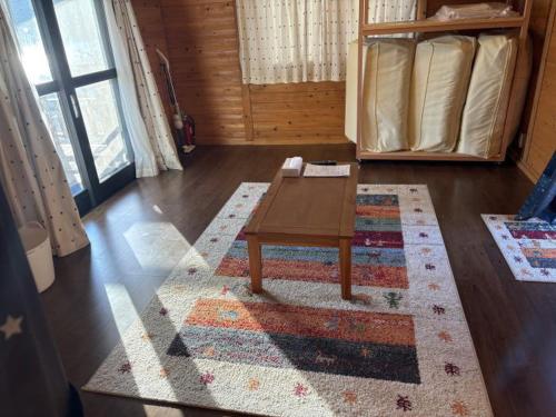 a living room with a coffee table on a rug at Costa Hinase Resort in Kakui-jima