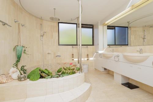 a bathroom with a tub and a sink and two sinks at The Rocks Resort - Official in Gold Coast