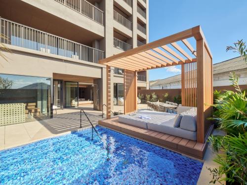 a bed and a swimming pool in front of a building at edit x seven SETOUCHI SHODOSHIMA in Shodoshima