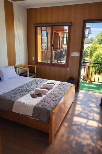 a bedroom with a large bed with a large window at Ngọc Trâm Homestay in A Lưới (1)